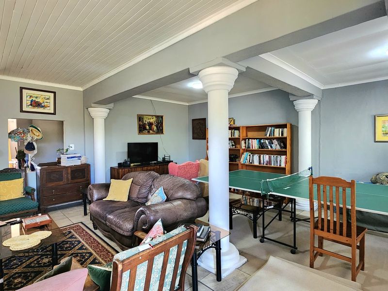 Spacious living area featuring structural columns, tiled flooring, and a tongue and groove ceiling, offering a versatile layout for relaxation and recreation.