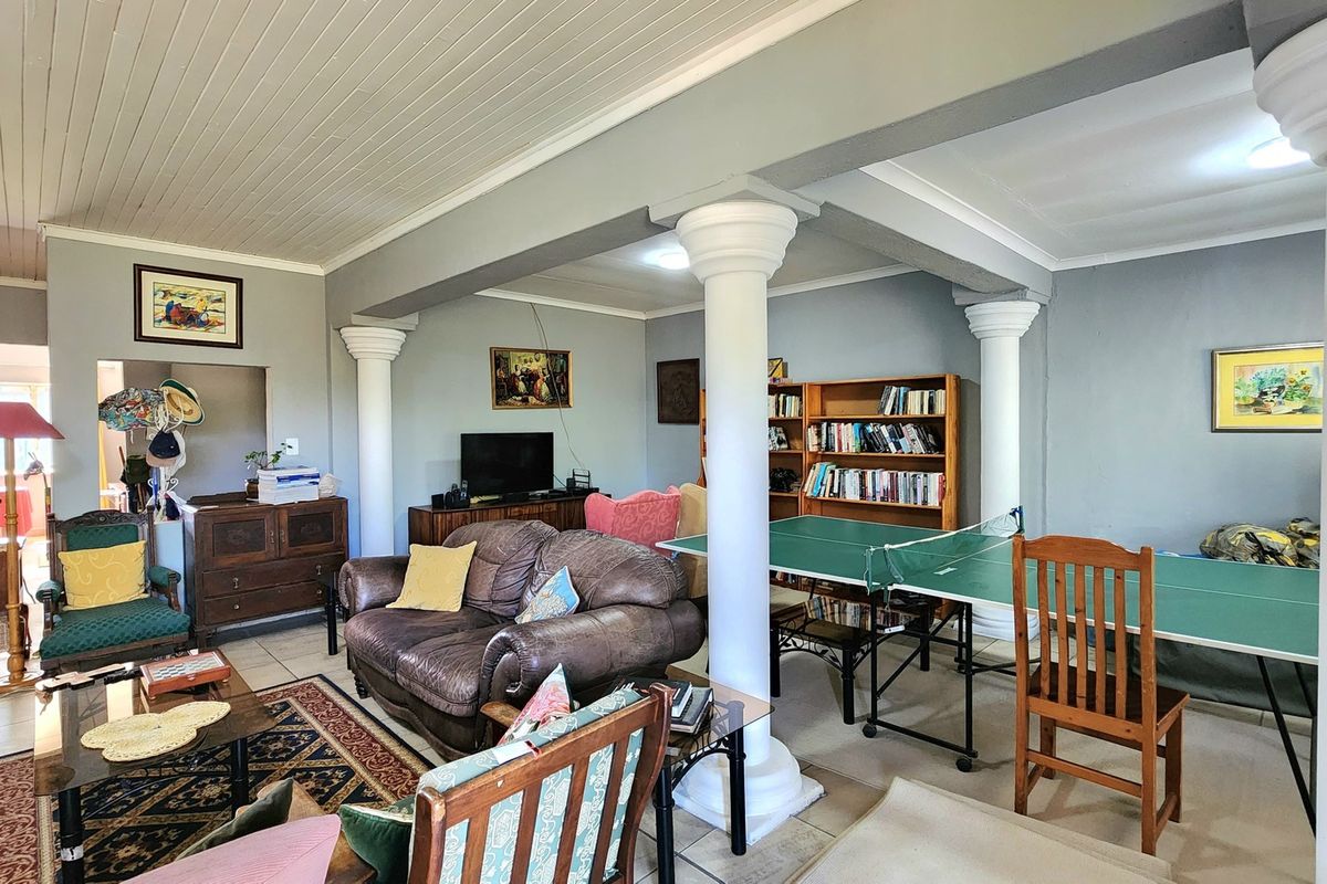 Spacious living area featuring structural columns, tiled flooring, and a tongue and groove ceiling, offering a versatile layout for relaxation and recreation.