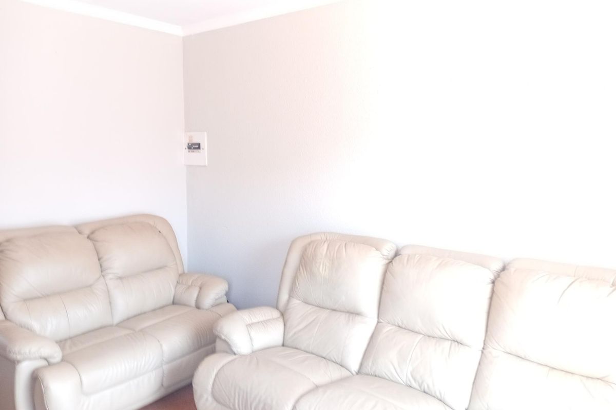 A living room area featuring neutral wall finishes and a visible electrical distribution board.