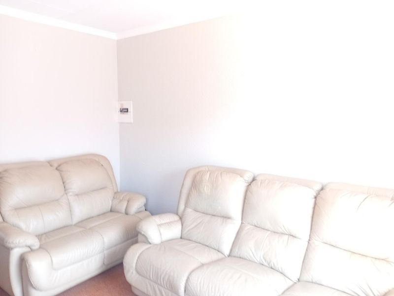 A living room area featuring neutral wall finishes and a visible electrical distribution board.