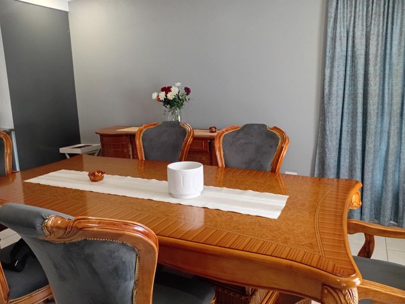 A dining room featuring neutral wall tones and classic finishes, providing a functional space for family meals and entertaining.