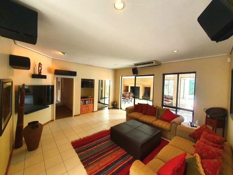 Spacious living room featuring tiled flooring, built-in cabinetry, and large sliding glass doors providing direct access to the outdoor patio area.