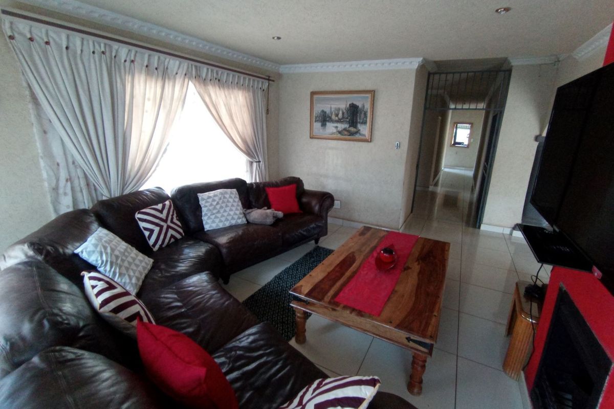 A comfortable living room featuring tiled flooring, recessed ceiling lighting, and a built-in fireplace, providing a functional and inviting space for relaxation.