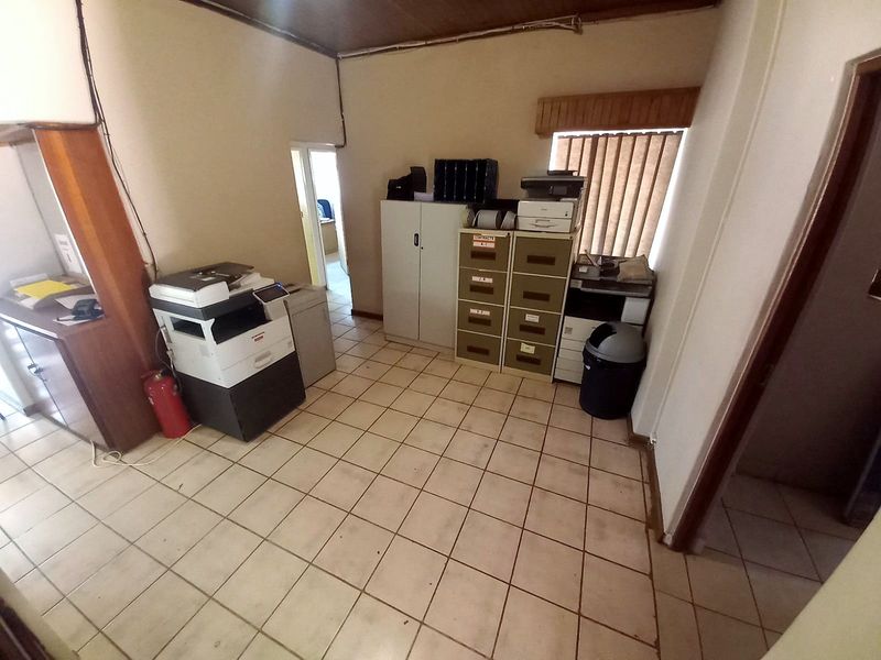 A functional utility space or office area featuring tiled flooring and built-in storage cabinetry, suitable for administrative use or storage.
