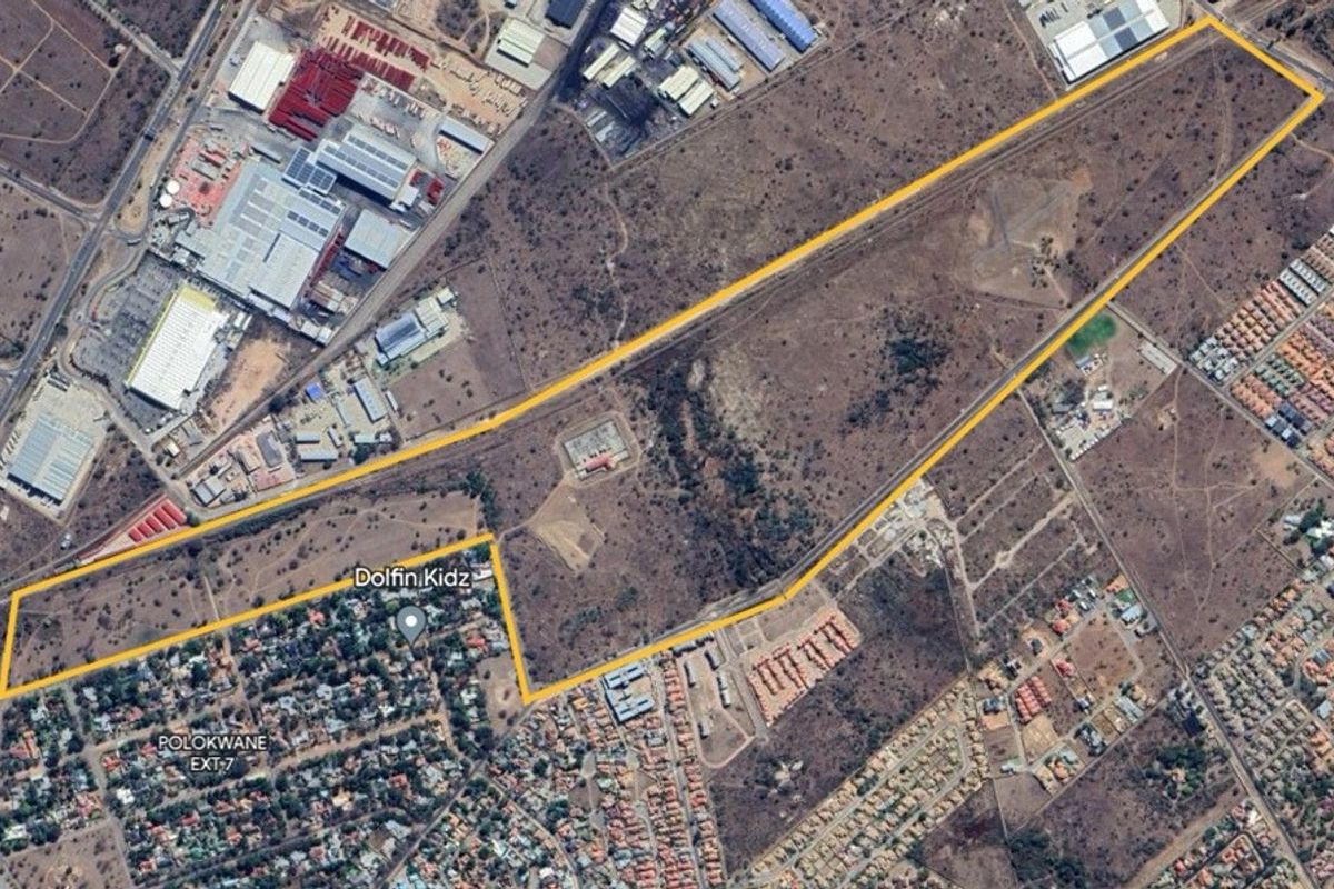 An aerial view of a large, undeveloped residential land parcel, highlighting its boundaries and proximity to existing urban infrastructure and residential developments.
