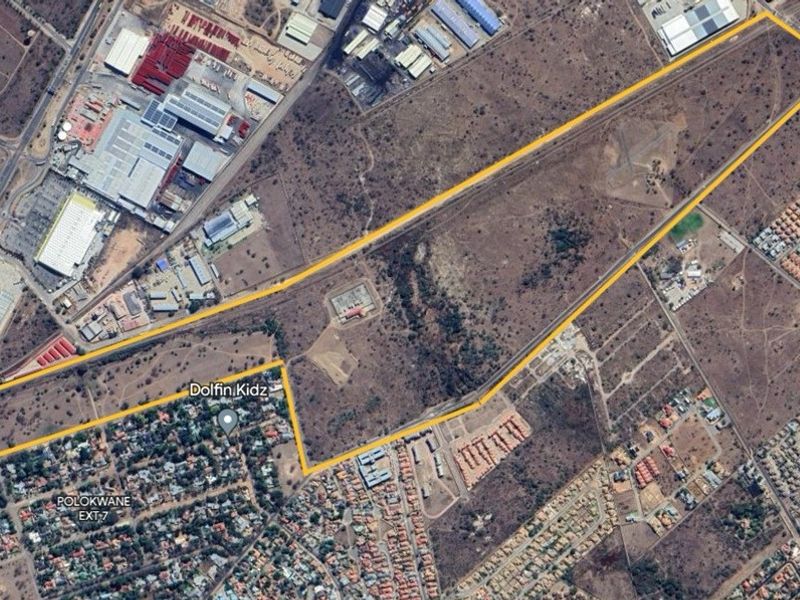 An aerial view of a large, undeveloped residential land parcel, highlighting its boundaries and proximity to existing urban infrastructure and residential developments.