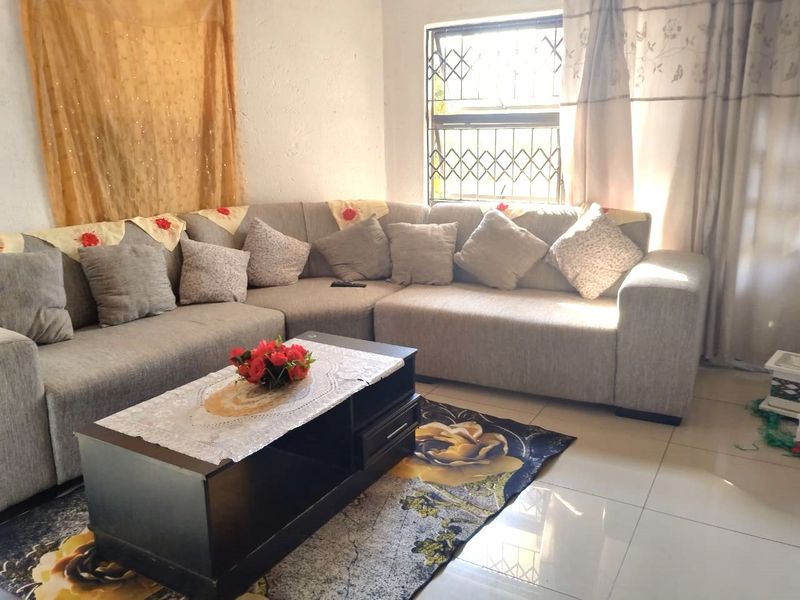 A living room featuring tiled flooring and a security gate on the window, providing a functional and secure living space.