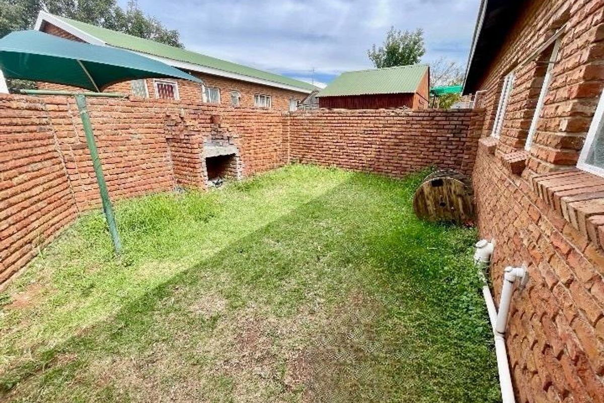 Private rear courtyard featuring a built-in brick braai, enclosed by high brick boundary walls with direct access to the main dwelling.