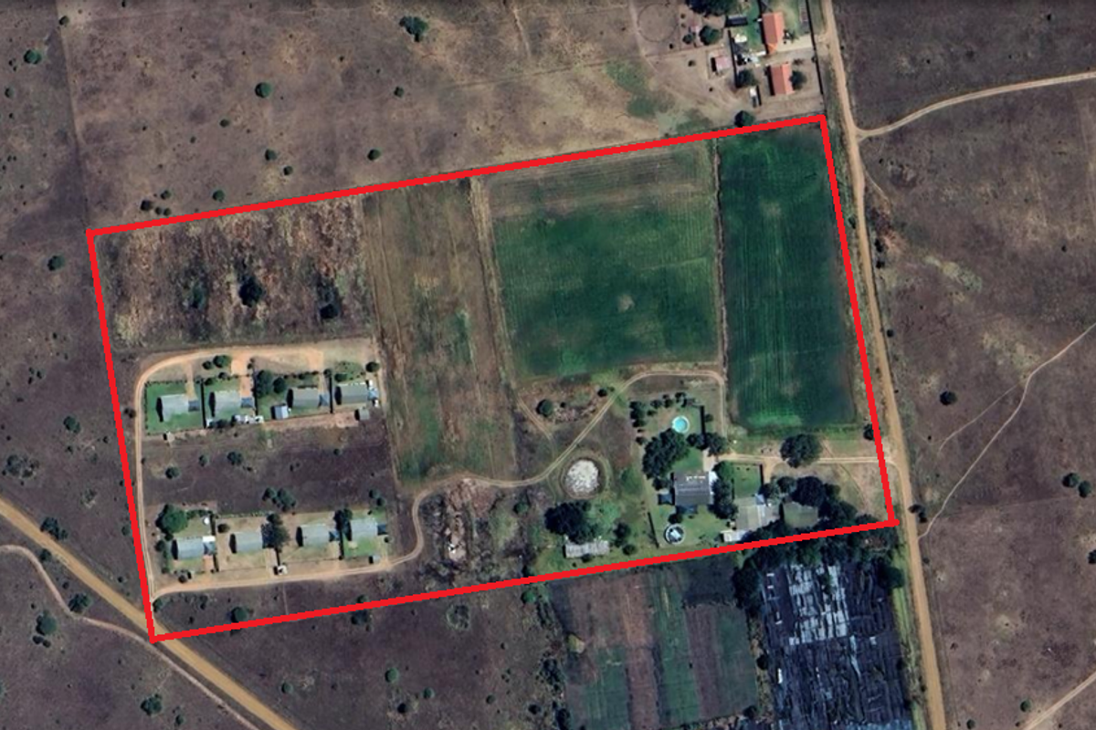 Aerial view of the small holding property showing multiple dwellings, a swimming pool, and expansive land with established access roads.