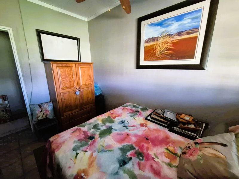 A bedroom featuring a ceiling fan and neutral wall finishes, providing a functional space for rest.
