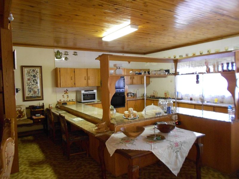 Open plan kitchen featuring wooden ceilings, granite countertops, and built-in cabinetry, offering a functional layout with a breakfast bar area.