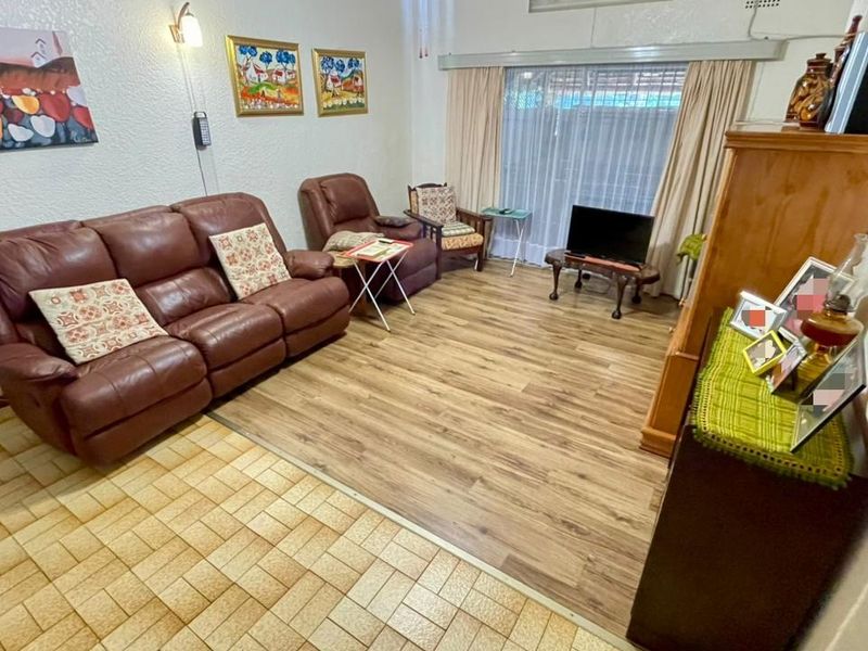 A living room featuring a combination of ceramic tile and laminate flooring with a sliding glass door providing access to the exterior.