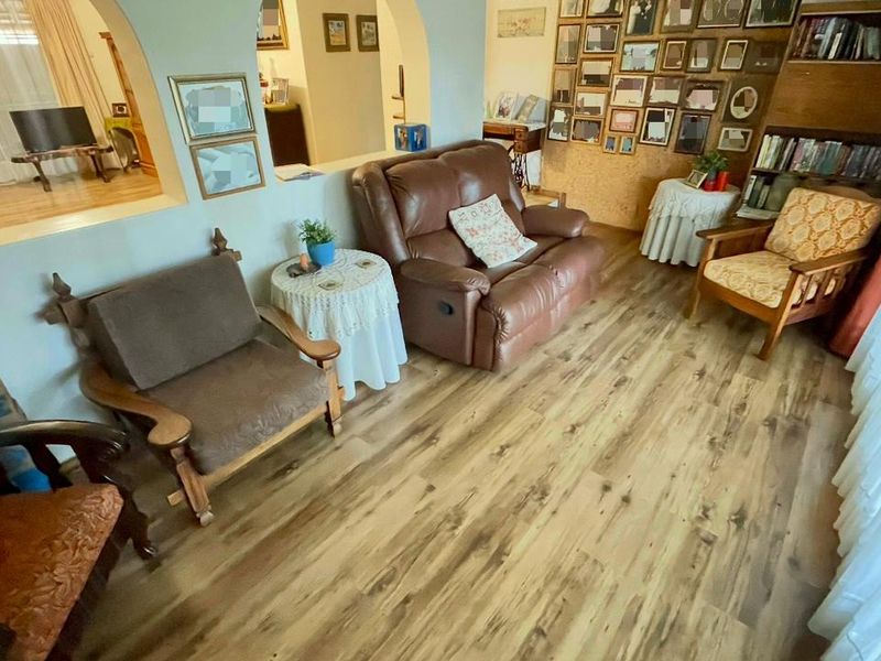 A cozy living room featuring durable laminate flooring, a distinctive architectural archway, and built-in shelving, creating a warm and inviting atmosphere.
