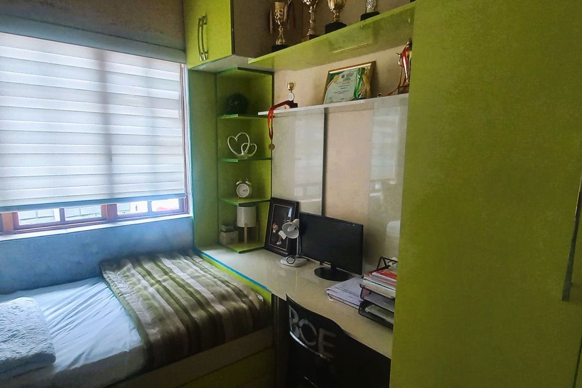 A compact bedroom featuring custom built-in cabinetry, including a desk, shelving, and wardrobe, with integrated window blinds.