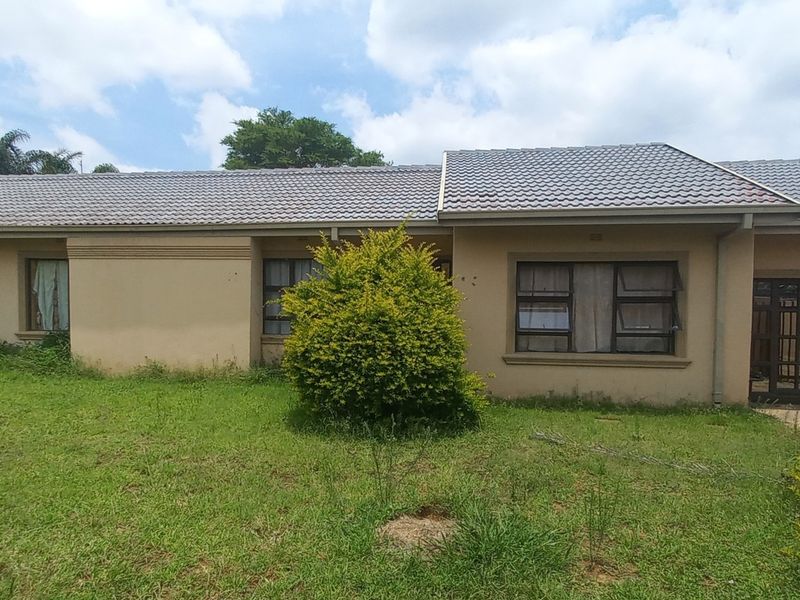 Front elevation of a single-story house featuring a tiled roof, aluminium window frames, and a front garden area.