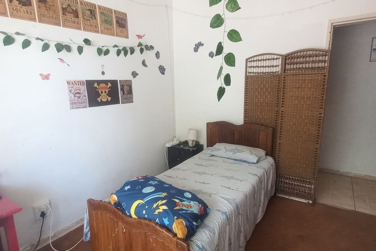 A bedroom featuring carpeted flooring and a doorway leading to an adjacent space.