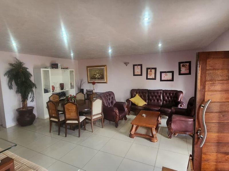 Spacious open-plan living and dining area featuring tiled flooring and recessed downlighting, providing a versatile layout for family living.