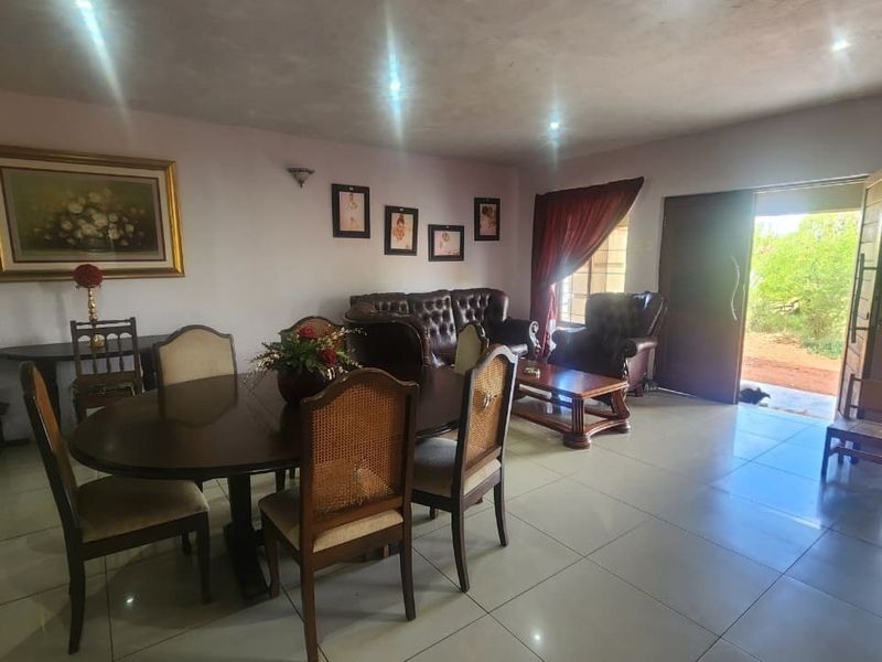 Spacious open-plan living and dining area featuring tiled flooring, recessed lighting, and direct access to the outdoor area through a sliding door.