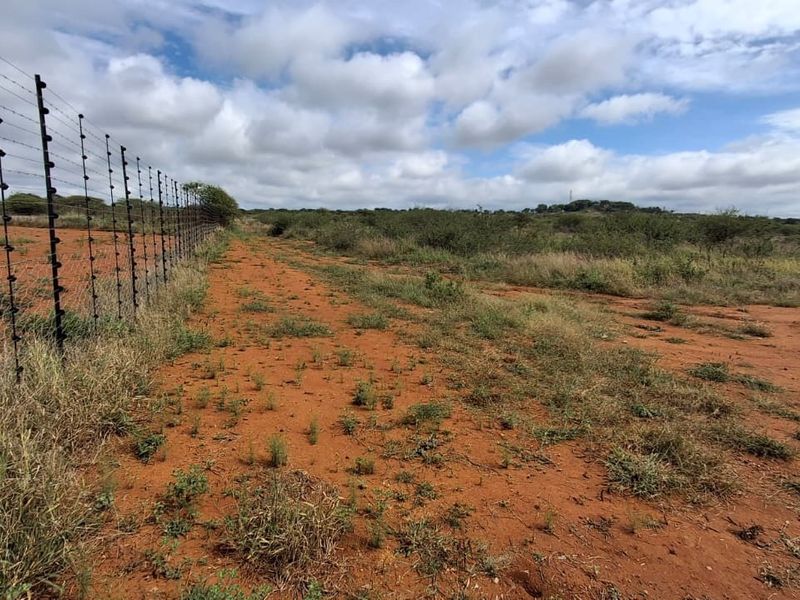 A view of the vacant residential land featuring established perimeter electric fencing and natural vegetation.