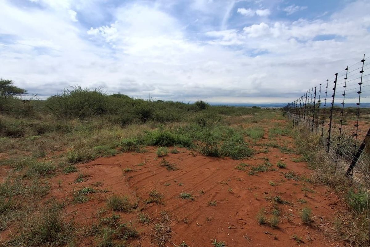 A view of the vacant residential land featuring natural vegetation and perimeter electric fencing.