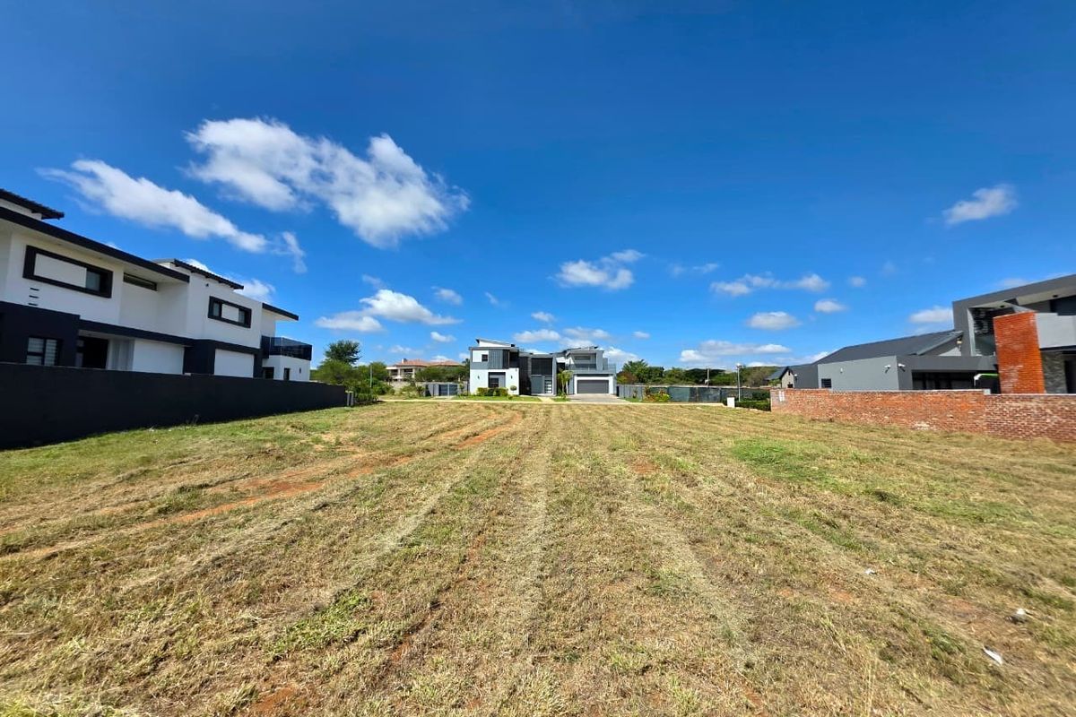 A vacant residential plot of land situated in a developed neighborhood, featuring established boundary walls and clear access for future construction.