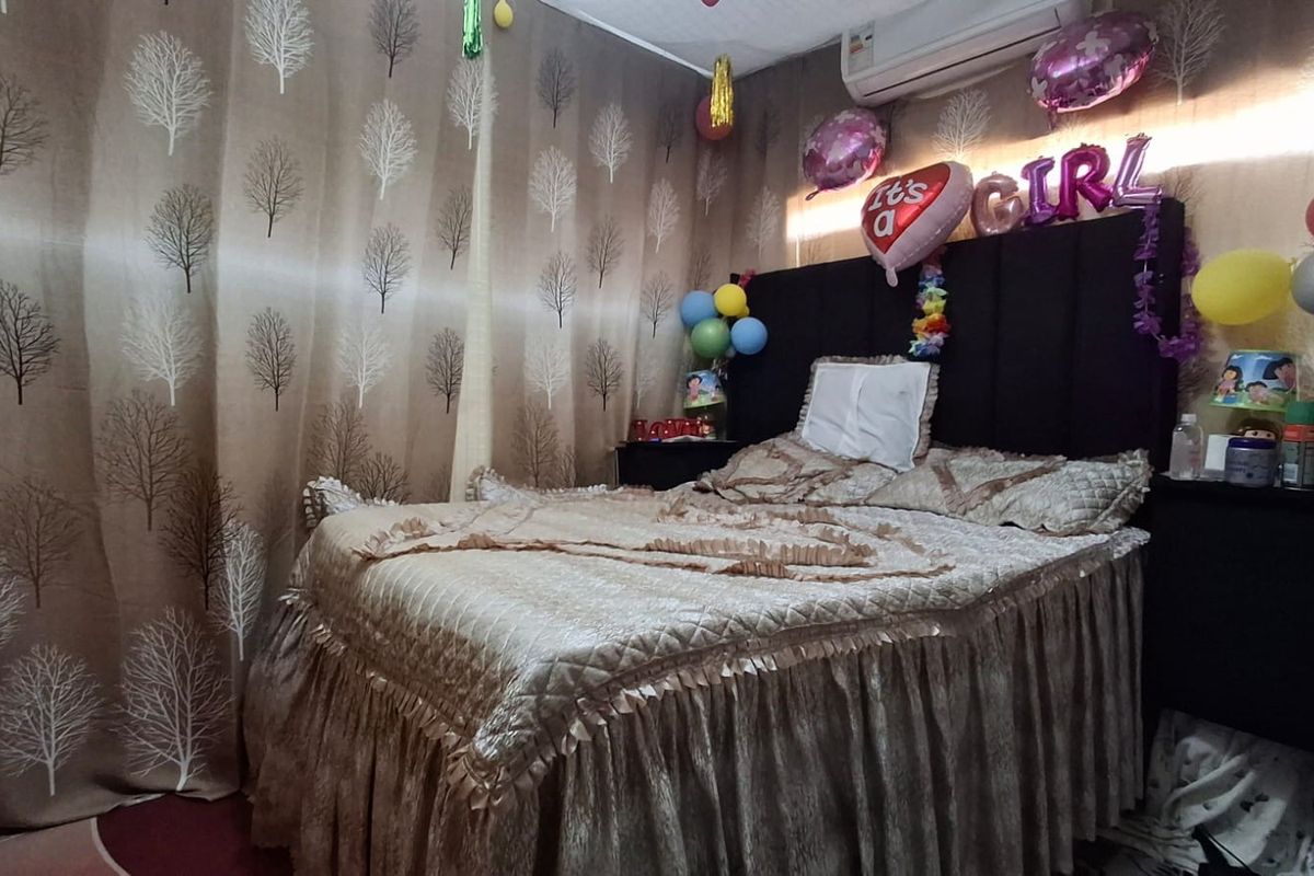 A bedroom featuring patterned wallpaper and a wall-mounted split-system air conditioning unit.