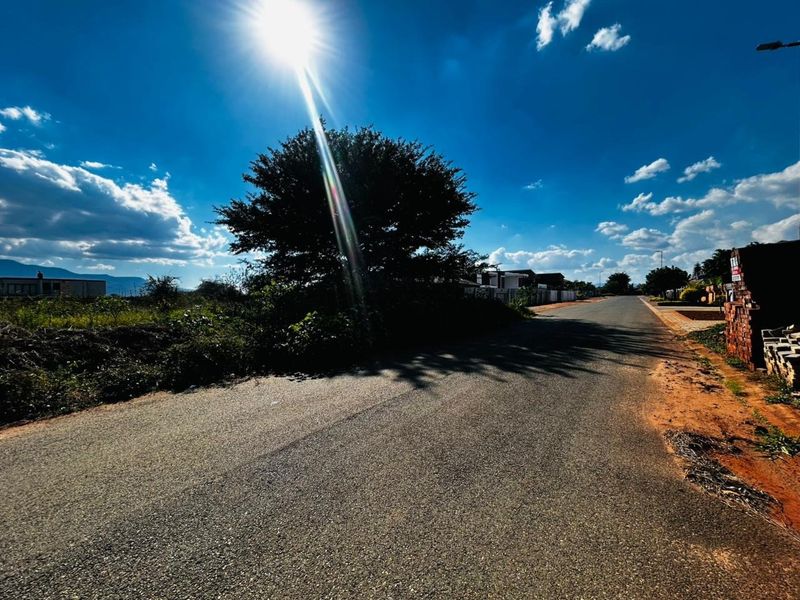 A view of the asphalt street and surrounding verge area, showing the approach to the residential land.