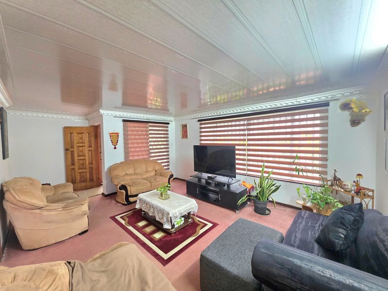 A living room featuring a tongue and groove ceiling, decorative cornice, and zebra blinds on the windows.