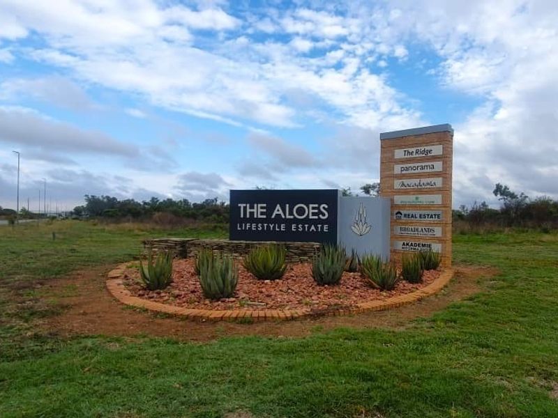 Entrance signage and landscaped garden bed for The Aloes Lifestyle Estate, featuring stone cladding and clear estate branding.