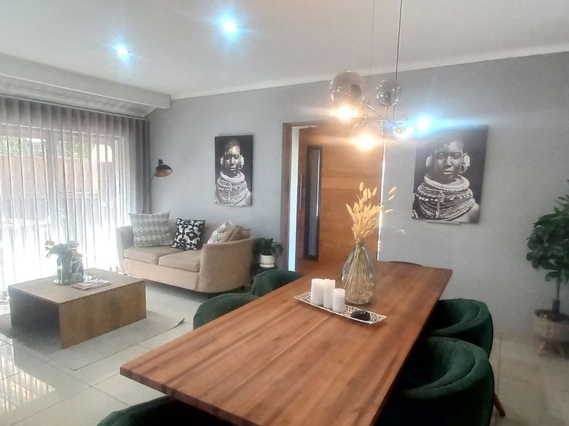 An open-plan living and dining area featuring tiled floors, recessed lighting, and large sliding doors that provide access to the outdoor space.