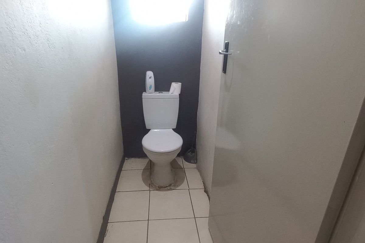 A small, functional guest toilet featuring a standard white toilet suite and tiled flooring.