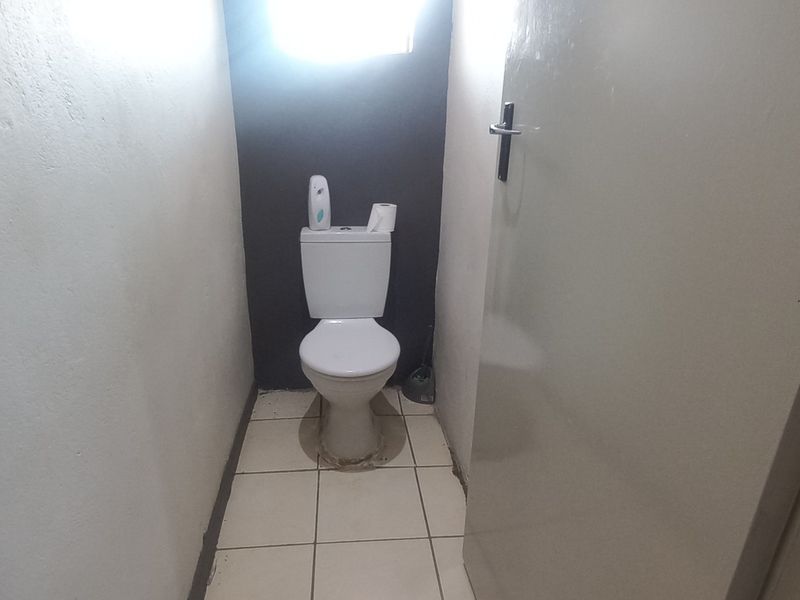 A small, functional guest toilet featuring a standard white toilet suite and tiled flooring.