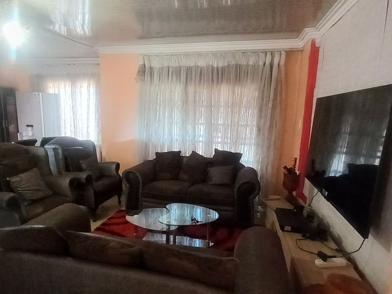 A living room featuring tiled flooring, coved ceilings, and sliding glass doors providing access to the exterior.