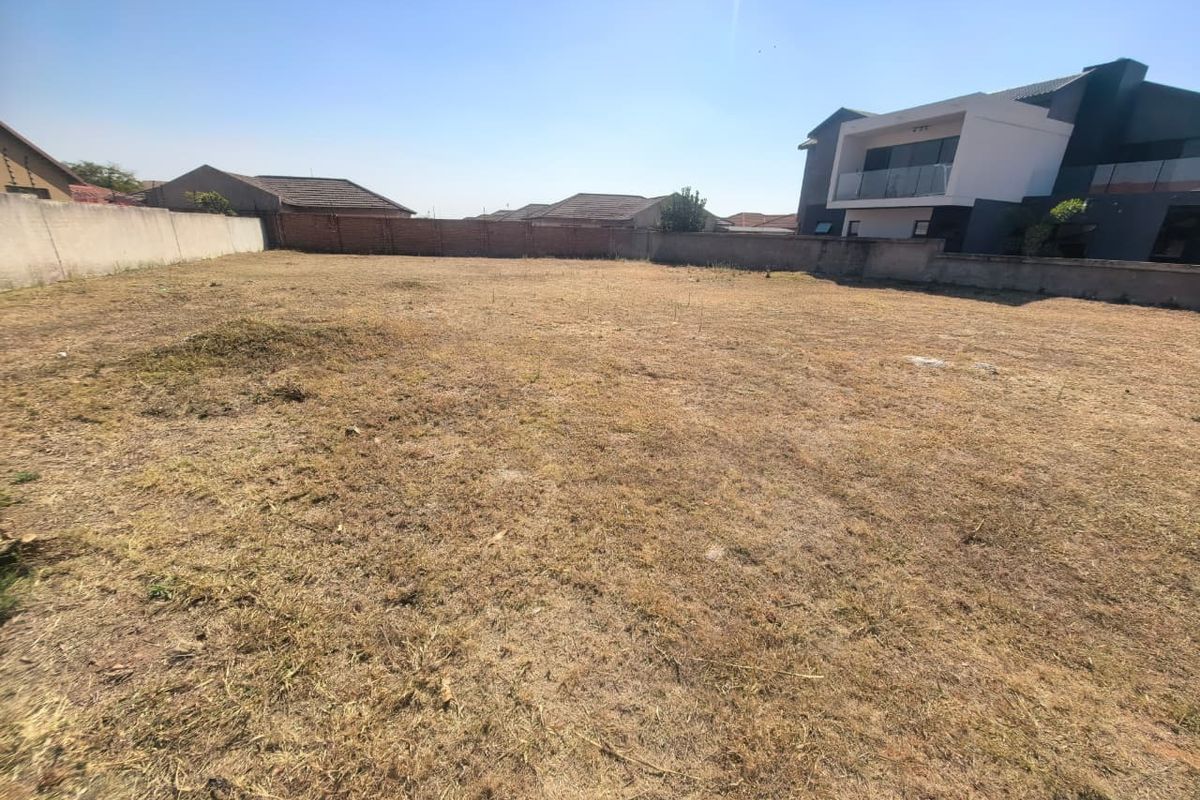 A vacant residential plot of land enclosed by perimeter boundary walls, offering a blank canvas for new construction in a developed neighborhood.