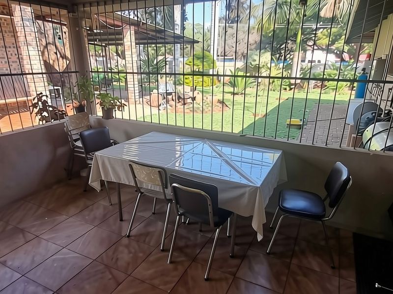 A covered patio area featuring tiled flooring, security bars, and external utility installations including a gas geyser and electrical distribution board.