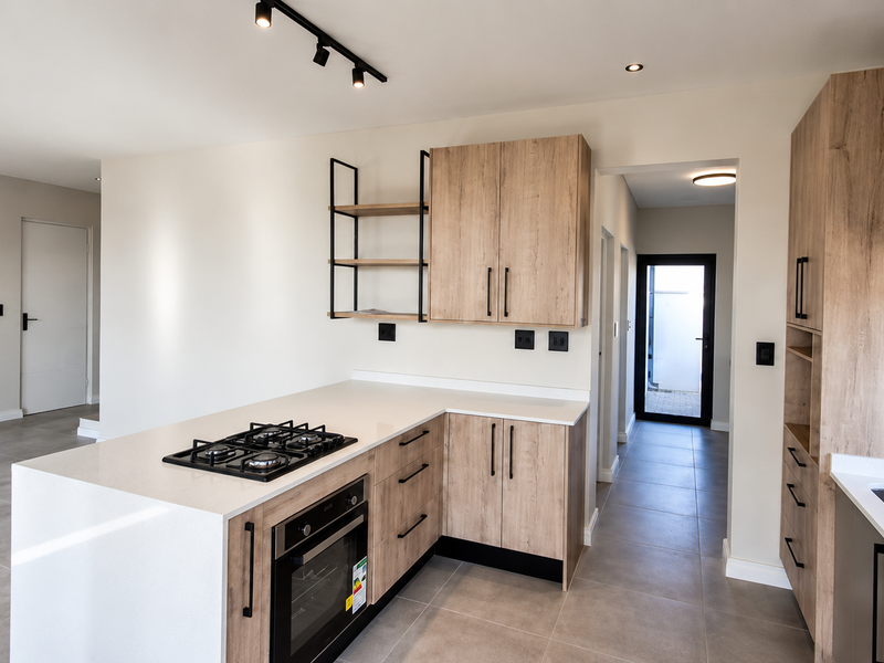 Modern kitchen featuring light wood cabinetry, stone countertops, a gas hob, built-in oven, and sleek tiled flooring in an open-plan layout.