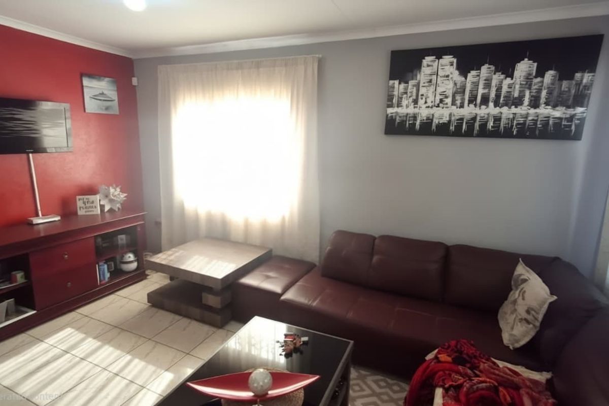 A living room featuring tiled flooring and a feature wall, providing a functional space for relaxation.