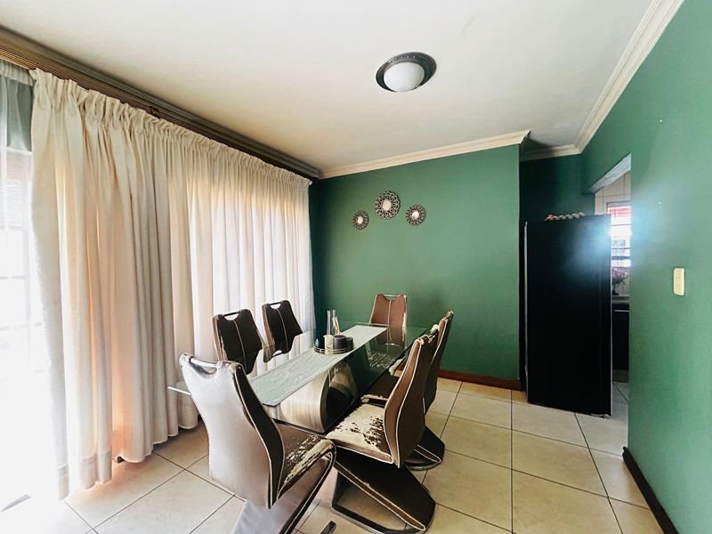 A dining room featuring tiled flooring, ceiling cornice, and a flush mount light fixture, with direct access to an adjacent area.