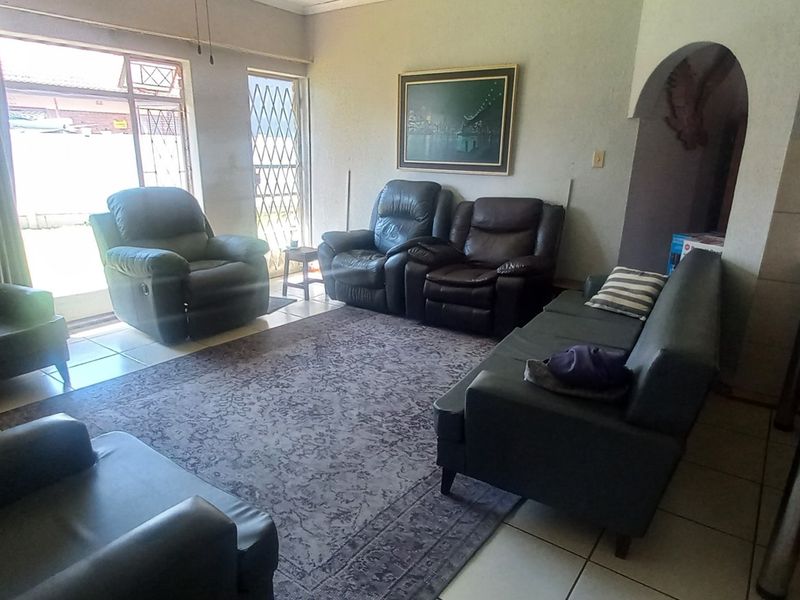 Open plan living area featuring tiled flooring, a breakfast bar, and a sliding glass door providing access to the exterior.