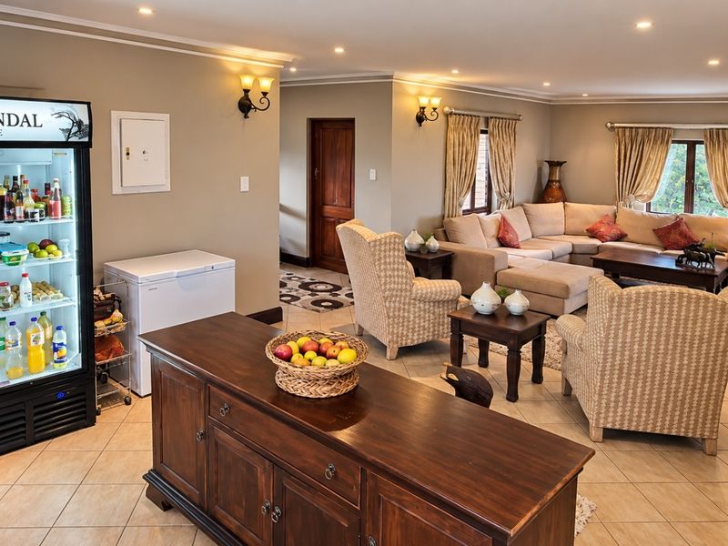 Spacious living area featuring tiled flooring, recessed downlighting, and wall sconces, providing a comfortable and well-lit space for relaxation.