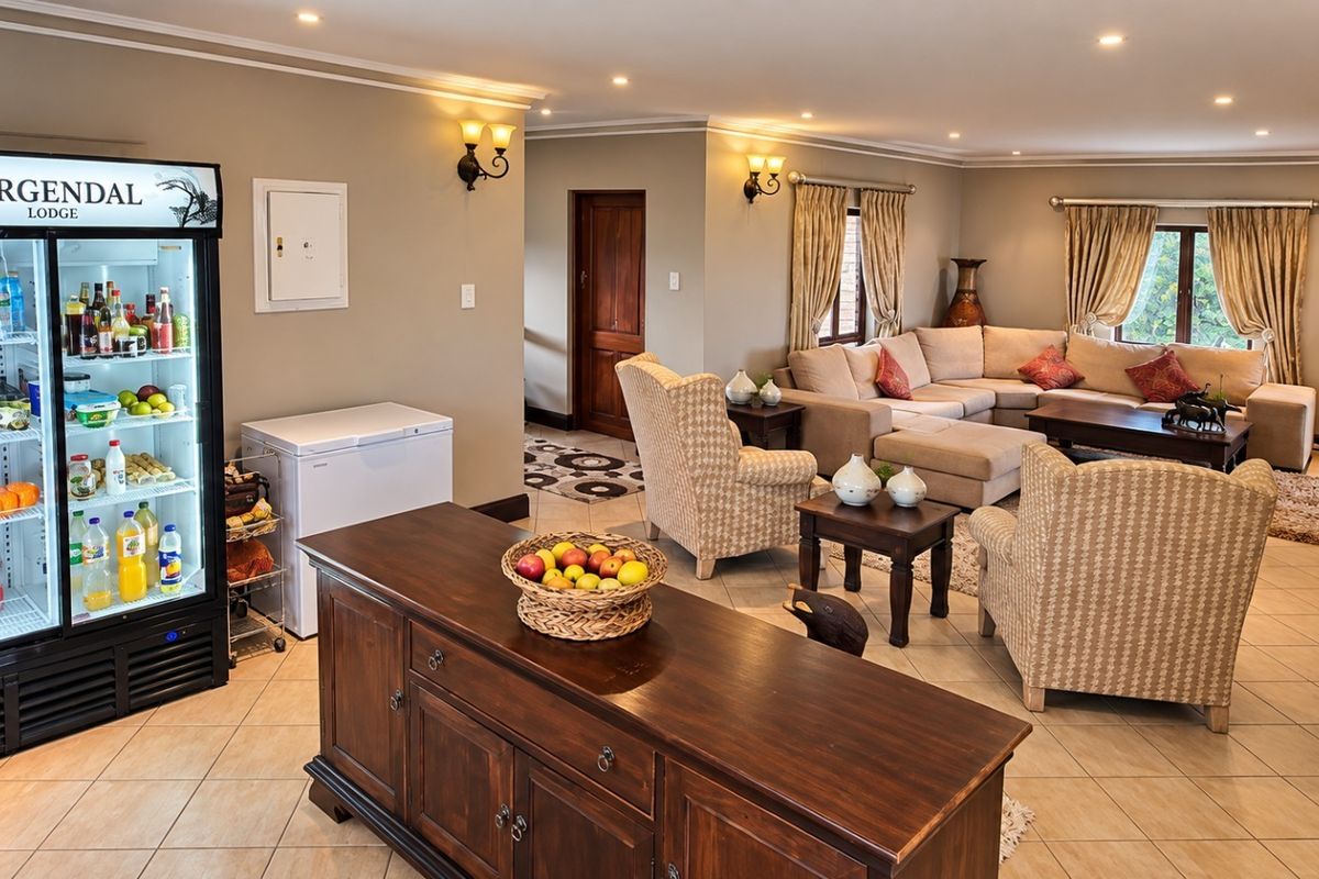 Spacious living area featuring tiled flooring, recessed downlighting, and wall sconces, providing a comfortable and well-lit space for relaxation.