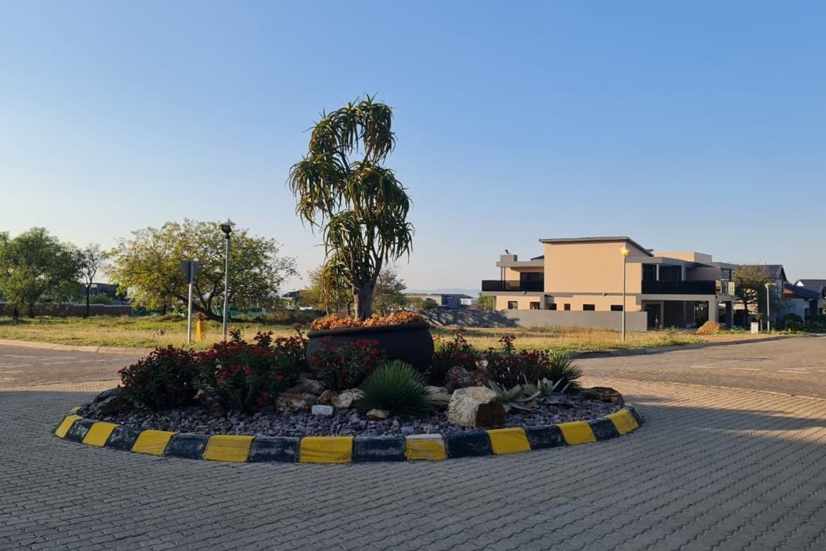 A view of a paved roundabout and landscaped traffic island within a residential estate setting.
