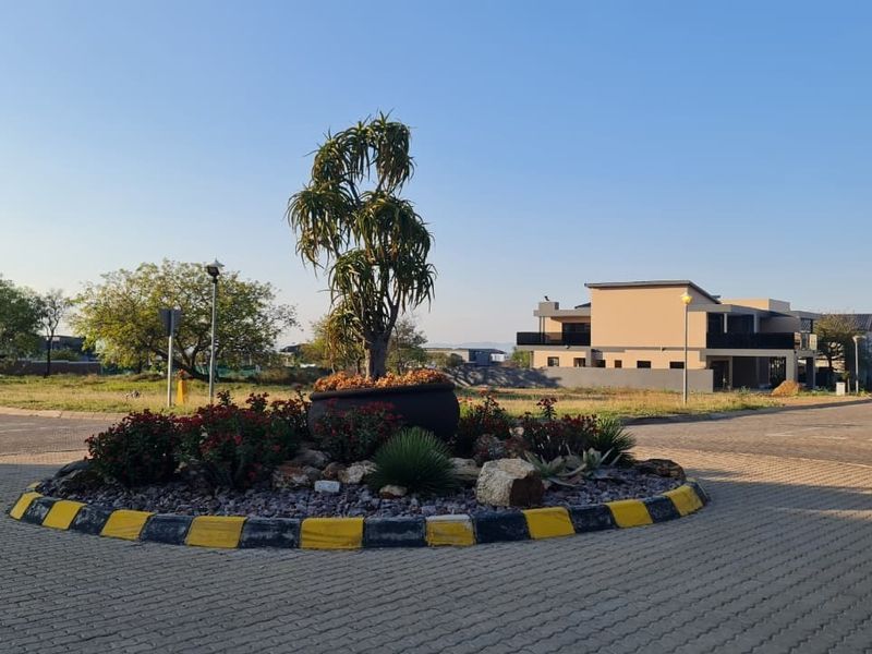 A view of a paved roundabout and landscaped traffic island within a residential estate setting.