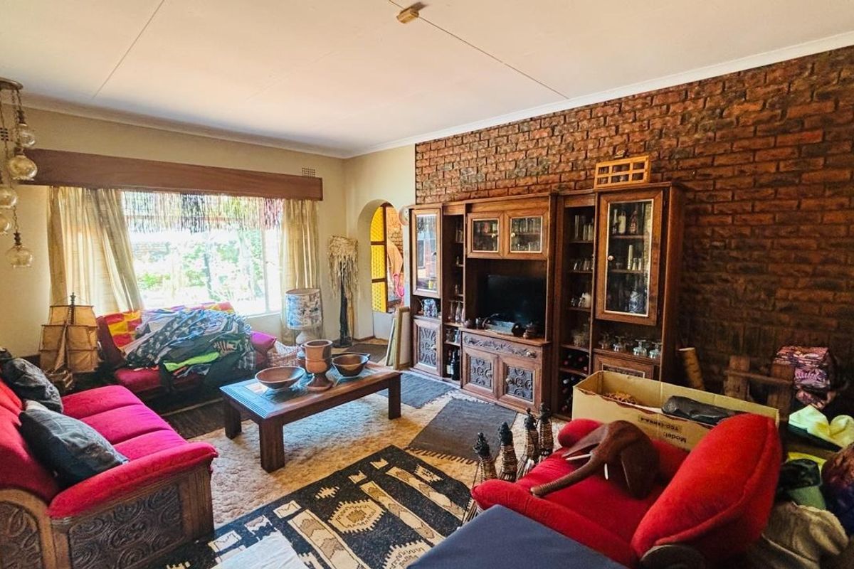 A living room featuring an exposed brick wall and built-in wooden cabinetry, offering a classic aesthetic with potential for modern updates.