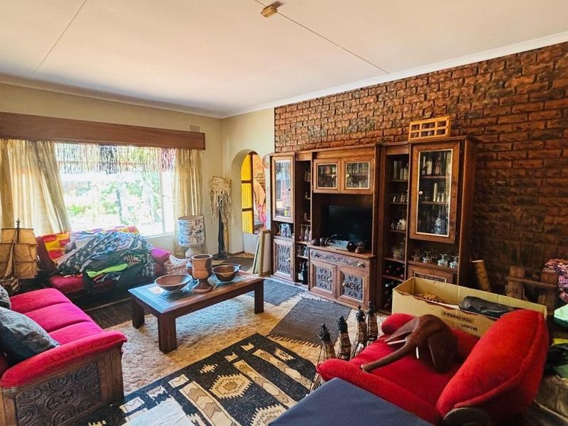 A living room featuring an exposed brick wall and built-in wooden cabinetry, offering a classic aesthetic with potential for modern updates.