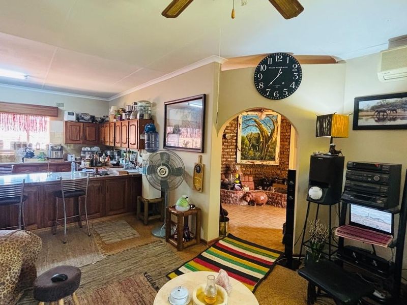 Open plan living area featuring a kitchen with wooden cabinetry and a breakfast island, leading through an arched doorway to an adjacent space.