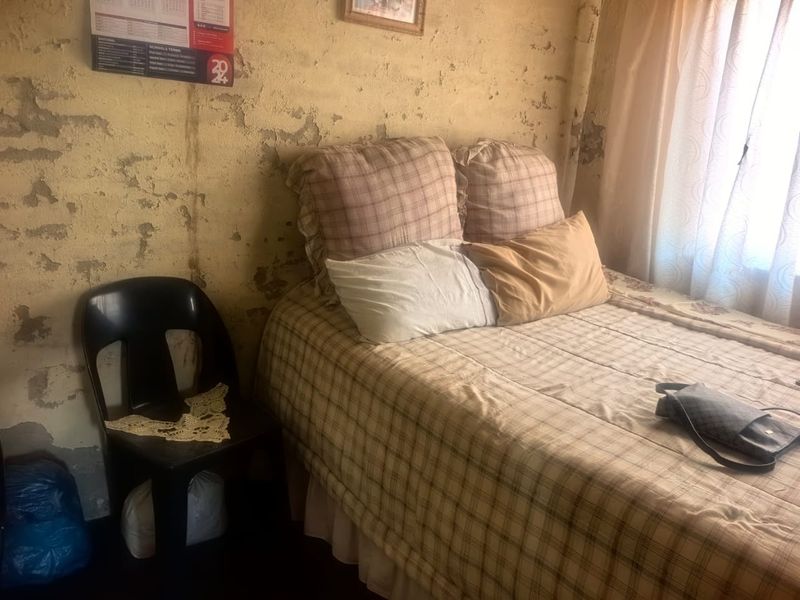 A bedroom featuring significant wall surface deterioration requiring plaster repair and repainting to restore the space.