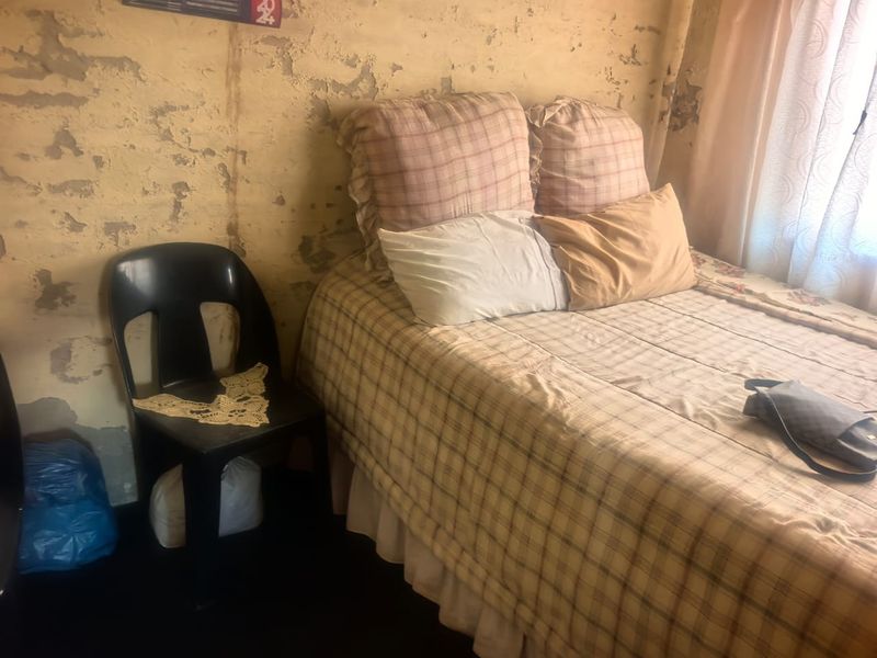 A bedroom featuring significant wall surface deterioration, requiring plaster repair and repainting to restore the interior finish.