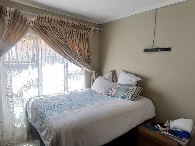 A standard bedroom featuring a large sliding glass door with curtain tracks, providing natural light and access to the exterior.