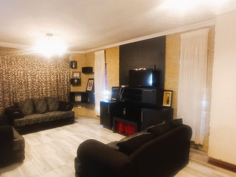 A living room featuring tiled flooring and a textured feature wall, providing a functional space for relaxation.